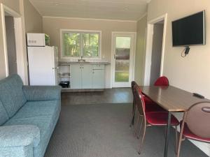 ein Wohnzimmer mit einem Tisch und einem Sofa sowie eine Küche in der Unterkunft Apple Motor Inn in Hastings