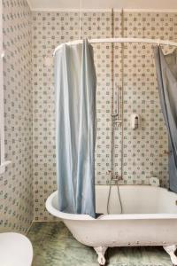 a bath tub with a shower curtain in a bathroom at Ambiente Hostel in Lisbon