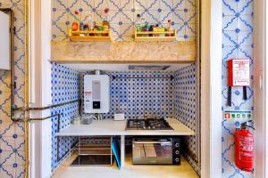 una pequeña cocina con paredes de azulejos azules y blancos. en Ambiente Hostel, en Lisboa
