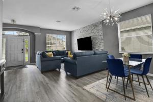 a living room with blue couches and a tv at Themed Luxury 6BR Getaway with Resort Amenities in Orlando