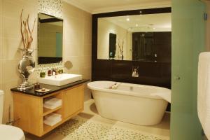 un bagno con vasca, lavandino e WC di Isango Gate a Port Elizabeth