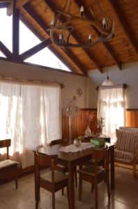 - un salon avec une table, des chaises et un plafond dans l'établissement Cabaña Piedra Hermosa, à Ñirihuau