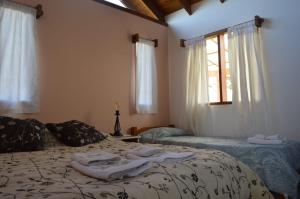 - une chambre avec un lit et des serviettes dans l'établissement Cabaña Piedra Hermosa, à Ñirihuau