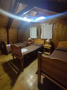 a bedroom with two beds and a light on the ceiling at La cumbrecita village in La Cumbrecita