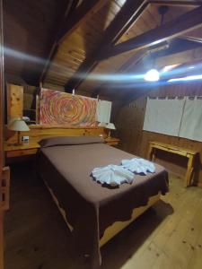 a bedroom with a bed with two towels on it at La cumbrecita village in La Cumbrecita