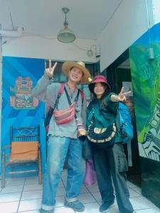 twee mensen met hoeden voor een gebouw bij MORENAS BACKPACKERs in Cuzco