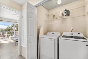 eine weiße Waschküche mit Waschmaschine und Trockner in der Unterkunft !! SNOWBIRD MONTHLY RATE 3300 !! 5min walk 2 Miramar Beach, Mins to Shopping, Steps to Pool, Patio and Yard, Dog Friendly, 1GB Wifi in Destin