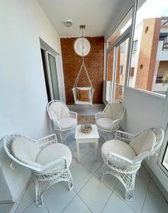 a balcony with white chairs and a table and a window at Dar Mustapha in Sidi Ifni