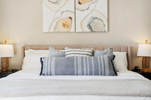 ein Schlafzimmer mit einem Bett mit blauen und weißen Kissen in der Unterkunft !! SNOWBIRD MONTHLY RATE 3300 !! 5min walk 2 Miramar Beach, Mins to Shopping, Steps to Pool, Patio and Yard, Dog Friendly, 1GB Wifi in Destin
