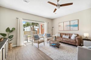 ein Wohnzimmer mit einer Couch und einem Deckenventilator in der Unterkunft !! SNOWBIRD MONTHLY RATE 3300 !! 5min walk 2 Miramar Beach, Mins to Shopping, Steps to Pool, Patio and Yard, Dog Friendly, 1GB Wifi in Destin