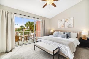 ein Schlafzimmer mit einem Bett und einem Balkon in der Unterkunft !! SNOWBIRD MONTHLY RATE 3300 !! 5min walk 2 Miramar Beach, Mins to Shopping, Steps to Pool, Patio and Yard, Dog Friendly, 1GB Wifi in Destin