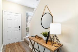 einen Flur mit einem Tisch mit einem Spiegel und einer Lampe in der Unterkunft !! SNOWBIRD MONTHLY RATE 3300 !! 5min walk 2 Miramar Beach, Mins to Shopping, Steps to Pool, Patio and Yard, Dog Friendly, 1GB Wifi in Destin