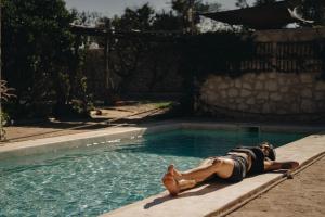 a woman laying on the edge of a swimming pool at Yogam villa Essaouira in Al Ghar