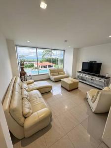 a large living room with couches and a television at Lujosa Finca El Ensueño Cerritos Pereira in Pereira +11 photos