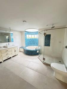 a bathroom with a shower and a tub and a toilet at Lujosa Finca El Ensueño Cerritos Pereira in Pereira