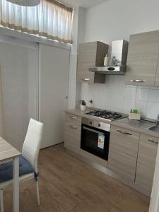 a kitchen with a stove and a chair and a table at Federica Apartment in Palermo