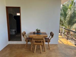 a wooden table with two chairs and a plant on it at Casa Mañana in Puerto Escondido