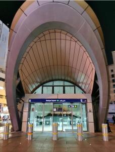 an airport entrance with a large building with a large ceiling at The Hosteller in Dubai