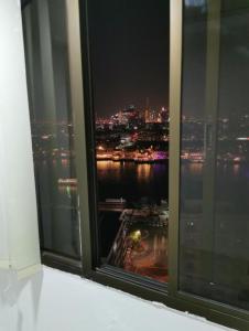 a window with a view of a city at night at The Hosteller in Dubai