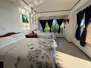 1 dormitorio con 2 camas y ventana en Hotel Coco Beach, en Manuel Antonio