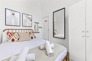 Un dormitorio con una gran cama blanca con espejos en Cosy place near Camden town en Londres
