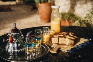 a table with a plate of bread and a bottle of juice at Yogam villa Essaouira in Al Ghar