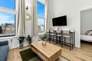 a living room with a couch and a table at Cosy place near Camden town in London