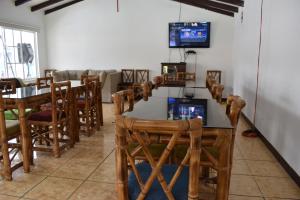 uma sala de jantar com mesa e cadeiras e uma televisão em La Casita de chocolate em Quito