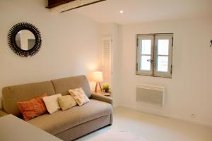 a living room with a couch and a window at Joli studio avec terrasse-jardin sur les toits, coeur historique in Montpellier