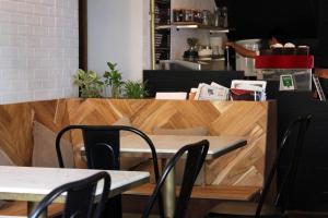 a table and chairs in a restaurant with a counter at The Old Quarter Hostel in Panaji