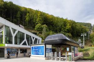 a building in front of a mountain with a ski lift at Studio Pablo Vila Bela Reka in Brzeće