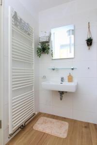 a white bathroom with a sink and a mirror at Galerija in Strmec Samoborski