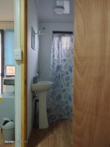 baño con lavabo y cortina de ducha en Cabañas Janico, en Loncoche