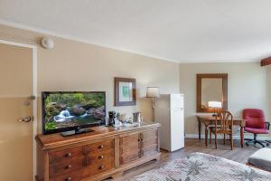 a bedroom with a television on a wooden dresser at Kauai Beach Resort Room 2309 in Lihue