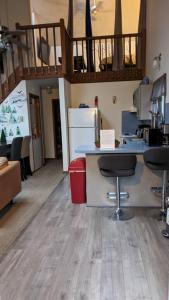 a kitchen with a counter and two bar stools at Oceans - KING BED Cabin Loft & Fireplace in Tobyhanna