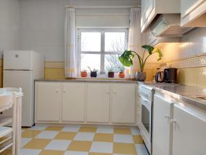 a kitchen with white cabinets and a window at Fortaleza Faro in Valença