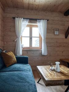 ein Wohnzimmer mit einem Sofa, einem Tisch und einem Fenster in der Unterkunft Peer Alm in Navis
