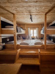 a room with three bunk beds in a log cabin at Peer Alm in Navis