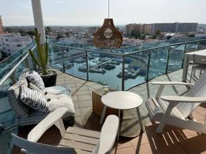 a balcony with a table and chairs and a view of a harbor at Appartement- rooftop à Rosas in Roses