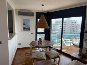 a living room with a table and a large window at Appartement- rooftop à Rosas in Roses
