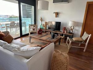 a living room with a couch and a table and a television at Appartement- rooftop à Rosas in Roses