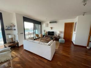 a living room with a white couch and wooden floors at Appartement- rooftop à Rosas in Roses +22 photos