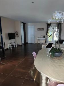 a living room with a table and a tv at Comme à la maison… in Pusignan