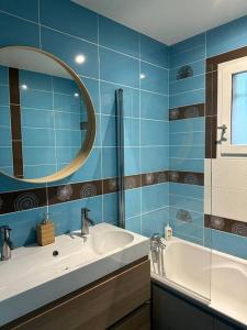 a bathroom with a sink and a mirror and a tub at Comme à la maison… in Pusignan