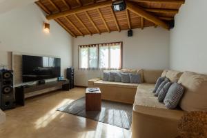 een woonkamer met een bank en een flatscreen-tv bij Paraíso Casa Branca in Arraial d'Ajuda