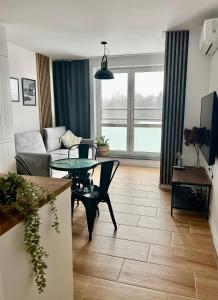 ジェシュフにあるApartament Przytuly 4, self check in, parking, blisko lotniskaのテーブルとソファのあるリビングルーム