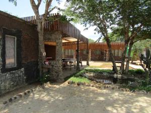 - une vue sur l'extérieur d'un bâtiment avec une table et des arbres dans l'établissement POVI Holiday Home, à Kasane