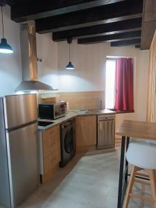 eine Küche mit Geräten aus Edelstahl und einem Tisch in der Unterkunft Apartamentos turisticos Ávila Puerta del Mariscal 1-1 in Avila