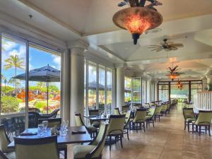 a dining room with tables and chairs and windows at Kauai Beach Resort Room 2309 in Lihue