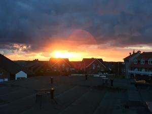 una puesta de sol en una ciudad con la puesta de sol en Ferienwohnung Penthaus Nordmarkhof Sylt Westerland en Westerland